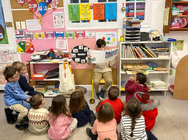 un élève de cm1 fait la lecture à la classe de maternelle moyenne section